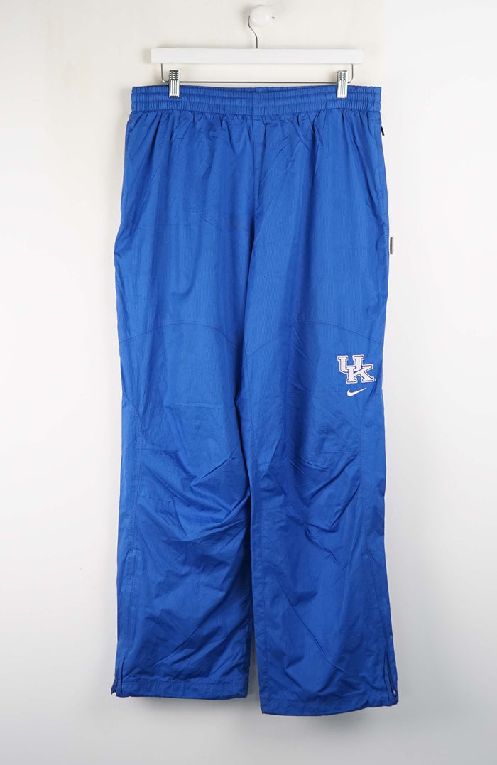 Blue athletic pants with a logo on a white background