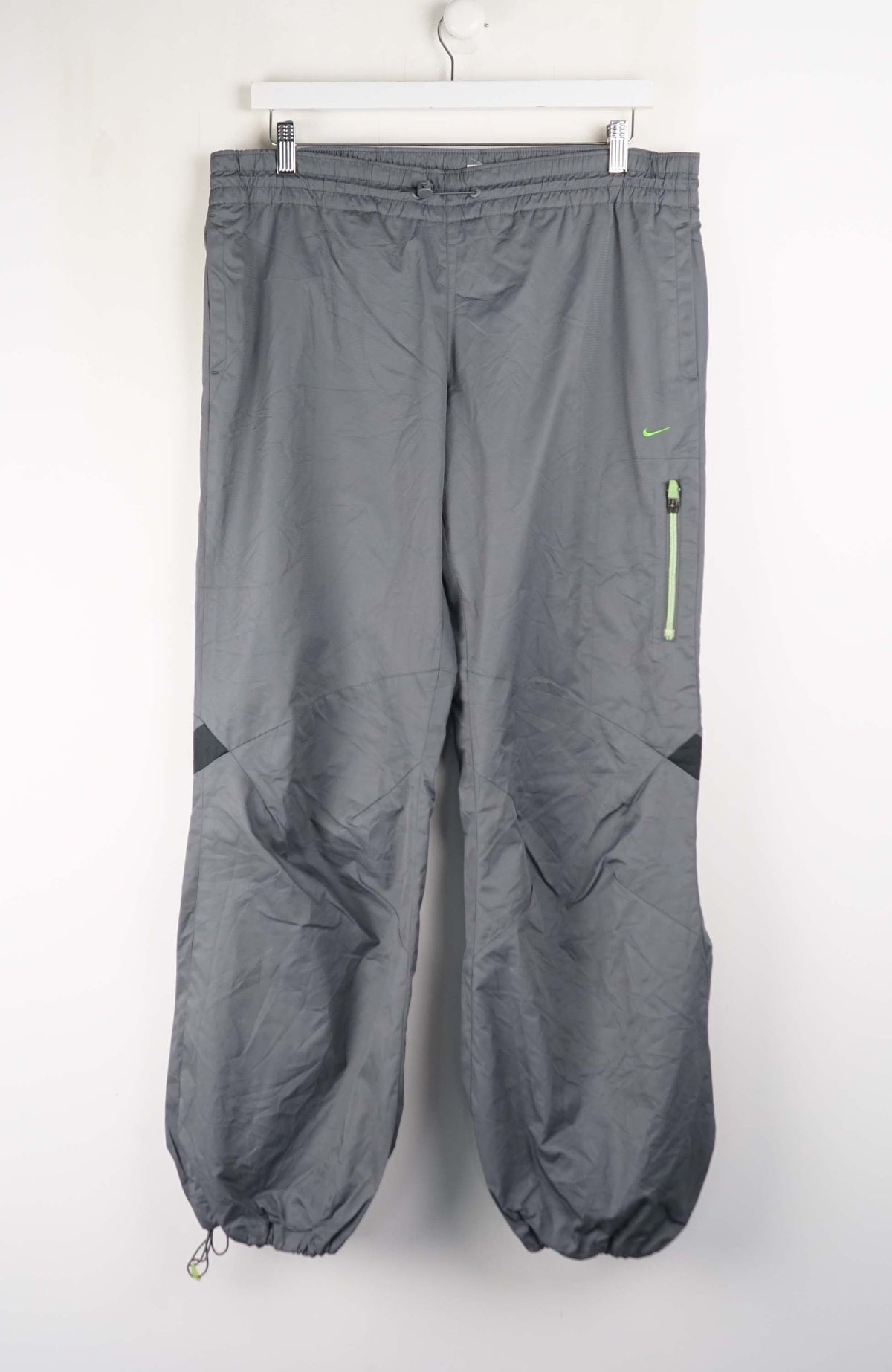 Gray pants with a green zipper on a white background
