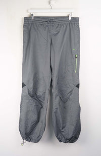 Gray pants with a green zipper on a white background