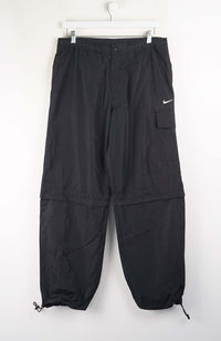Black cargo pants with a Nike logo on a white background