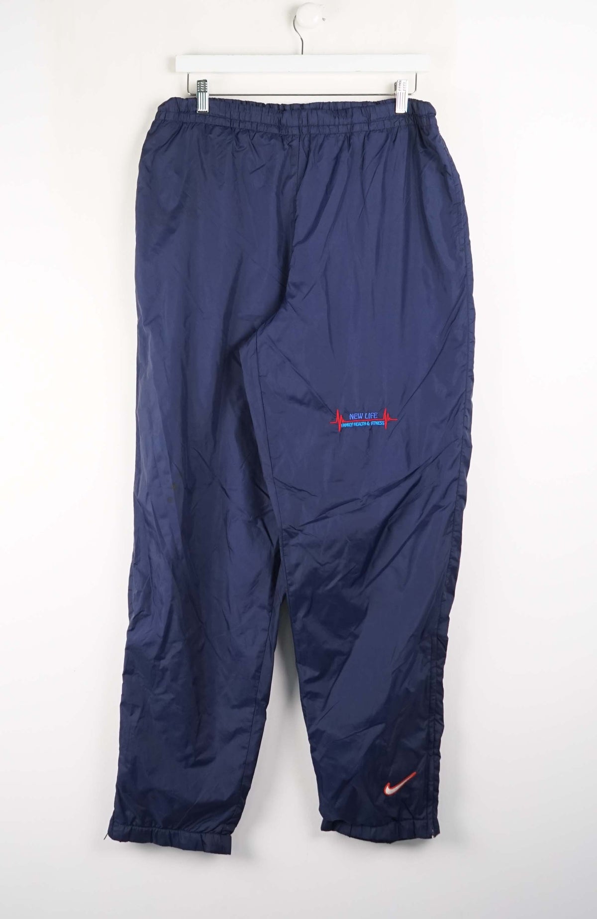 Navy blue pants with Nike logo on a white background