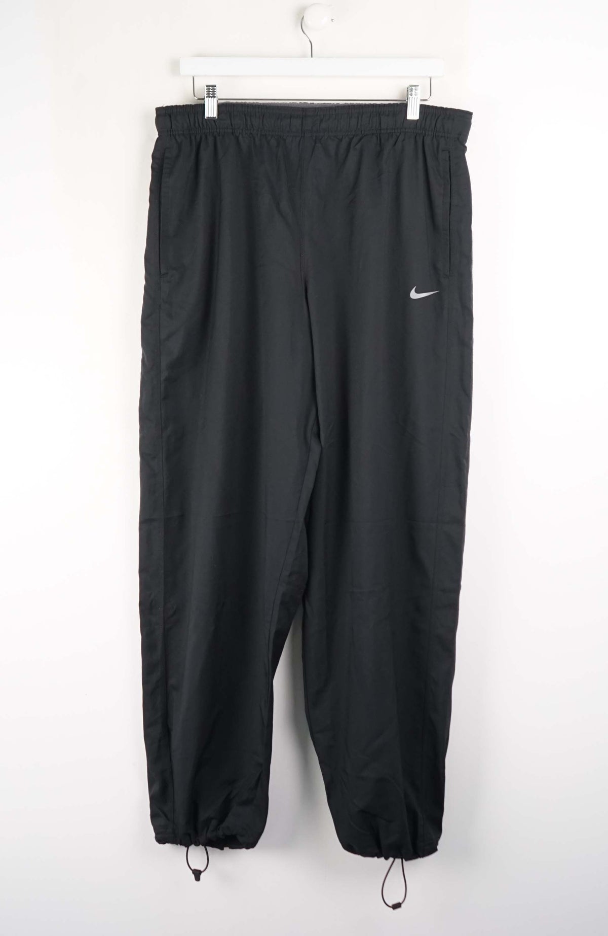 Black pants with a Nike logo on a white background