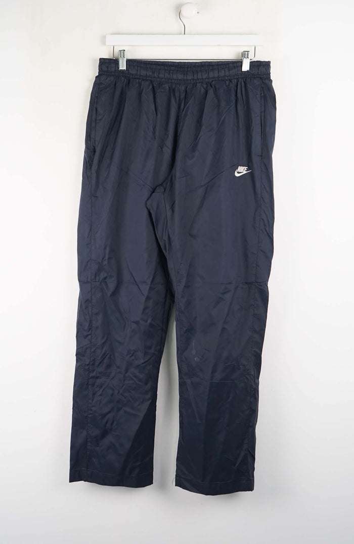 Dark blue pants with a Nike logo on a white background