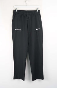 Black Nike pants with a logo on a white background