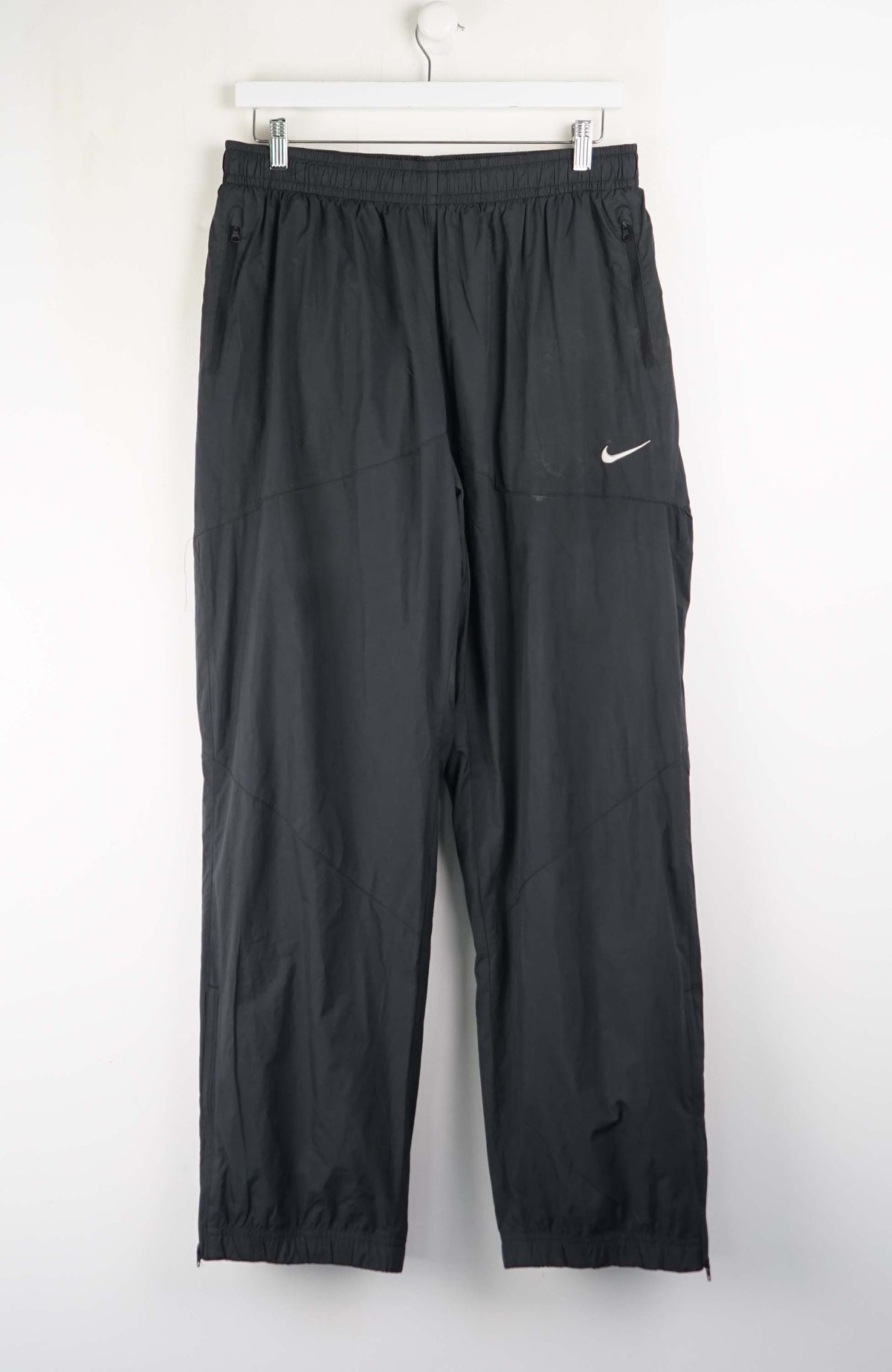 Black pants with a Nike logo on a white background