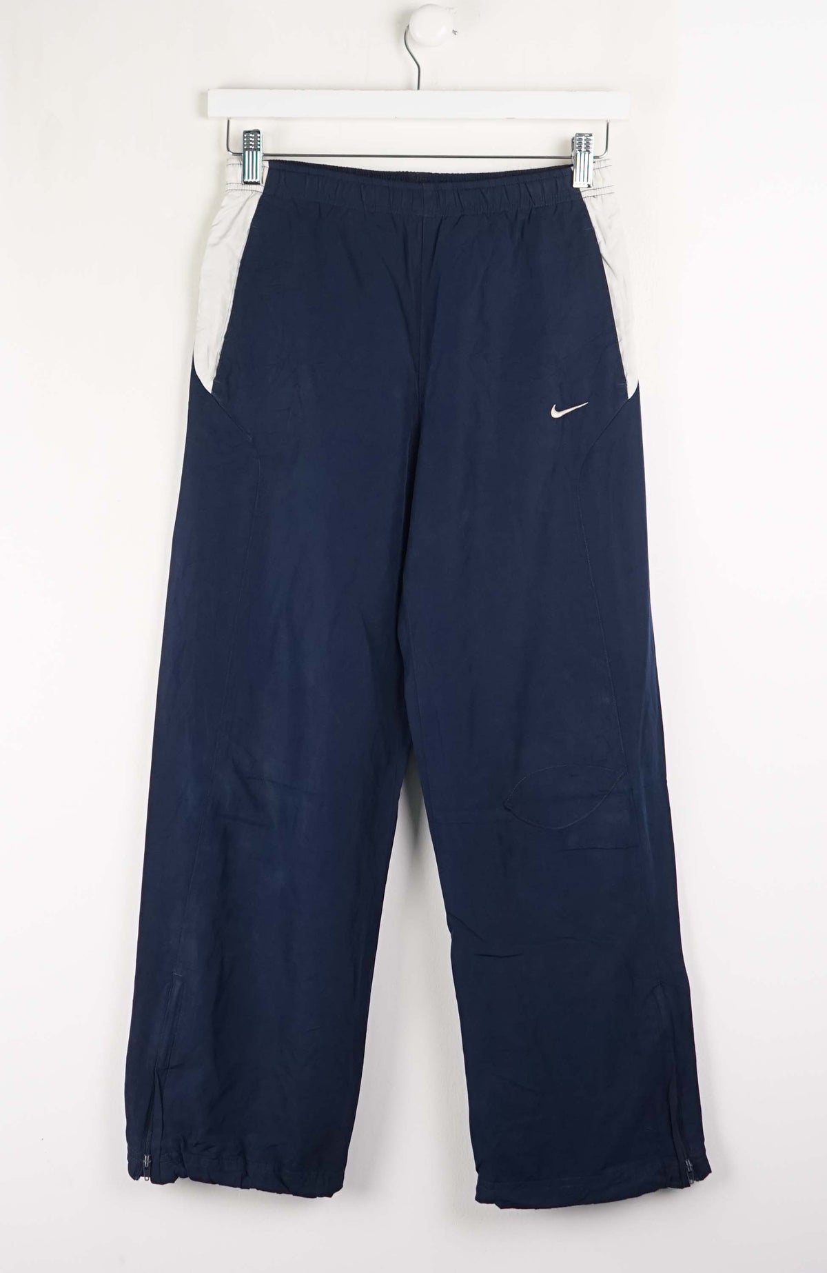 Navy blue pants with a Nike logo on a white background