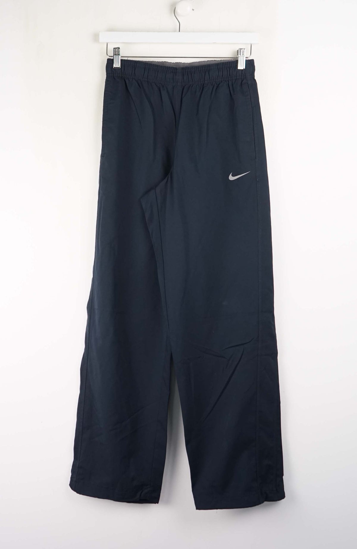 Dark blue athletic pants with a Nike logo on a white background