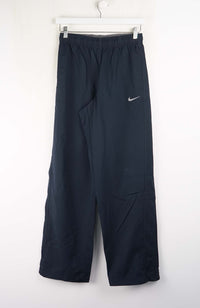 Dark blue athletic pants with a Nike logo on a white background