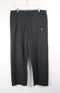 Black pants with a Nike logo on a white background