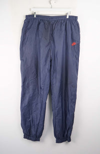 Blue tracksuit pants with a red logo on a white background