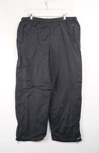 Black pants hanging on a white hanger against a white background