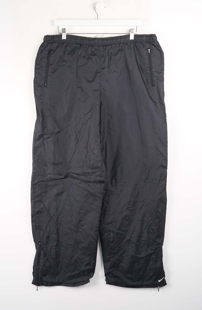 Black pants hanging on a white hanger against a white background
