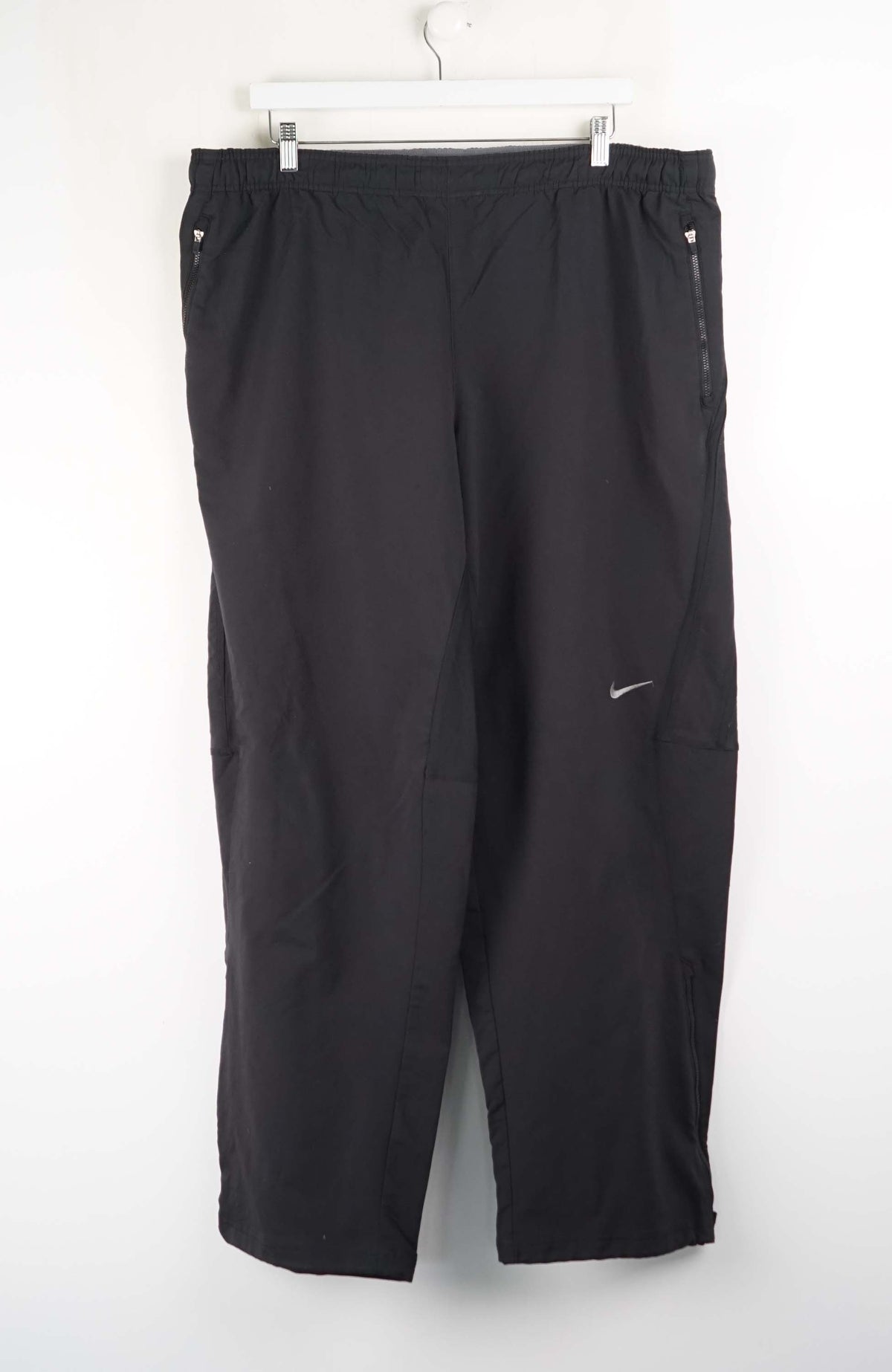 Black pants with a Nike logo on a white background