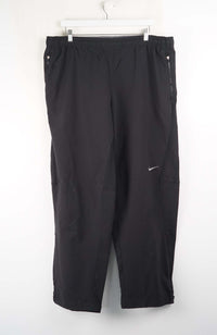 Black pants with a Nike logo on a white background