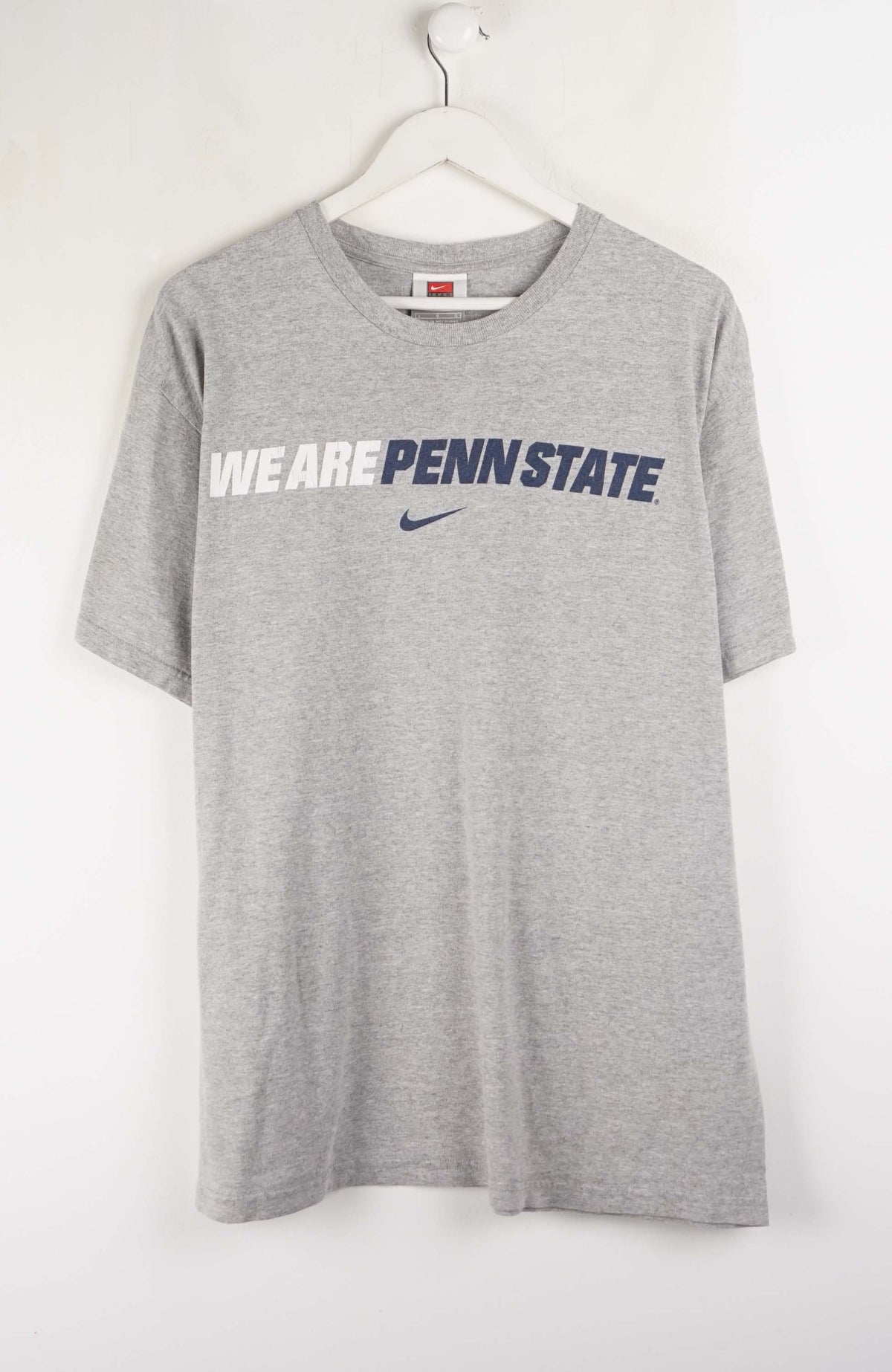 Gray t-shirt with 'We Are Penn State' text and Nike logo on a white background