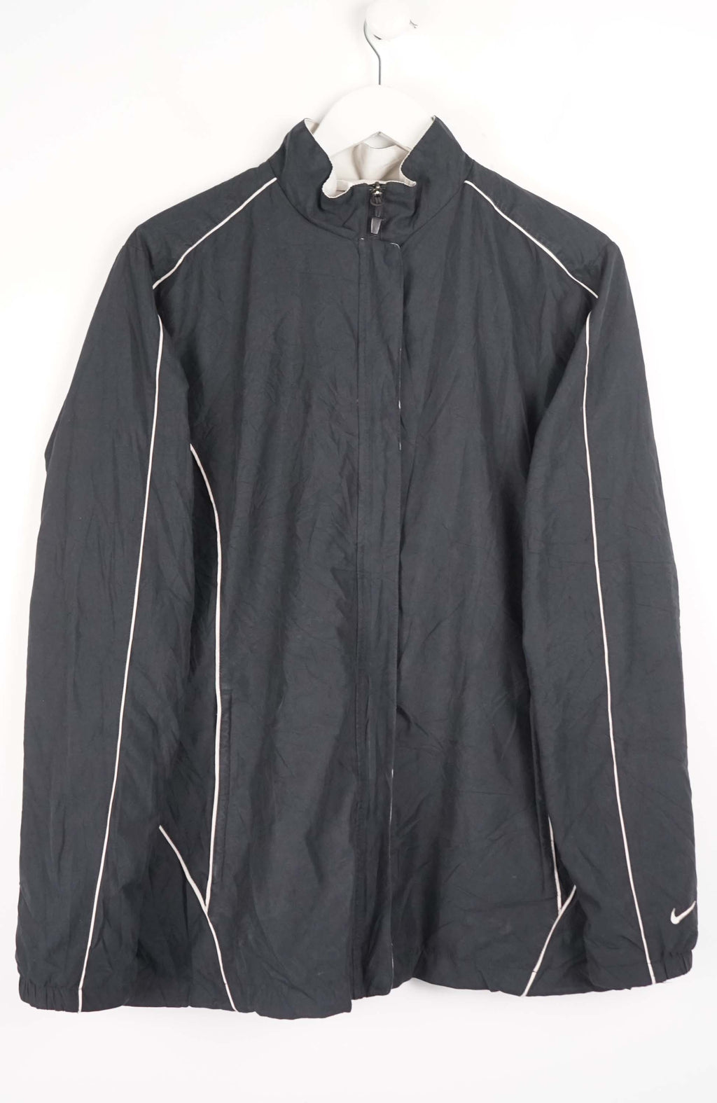 Black jacket with white accents on a hanger against a white background