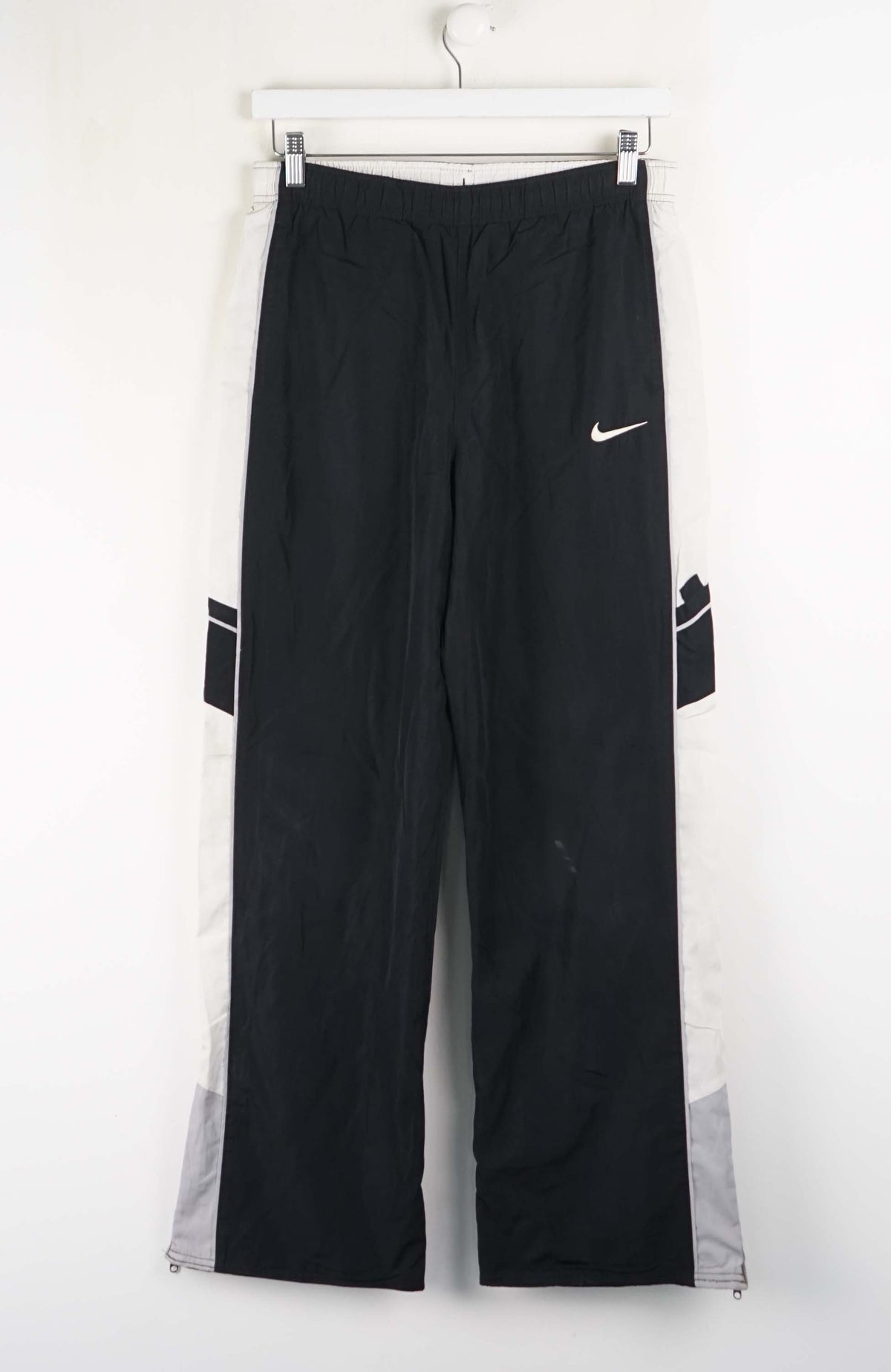 Black jeans on a hanger against a white background