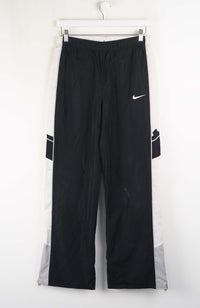 Black jeans on a hanger against a white background