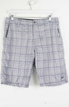 Plaid shorts hanging on a white background