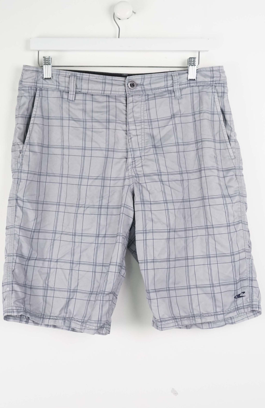 Plaid shorts hanging on a white background