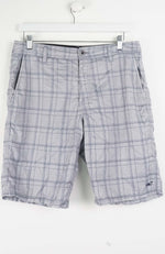 Plaid shorts hanging on a white background