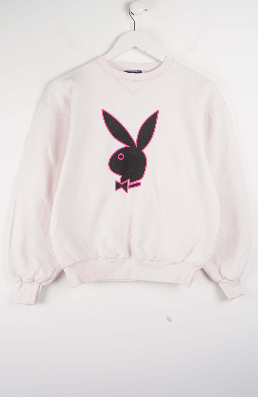 Pink sweatshirt with Playboy bunny logo on a white background