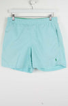 Light blue shorts with a brand logo on a white background