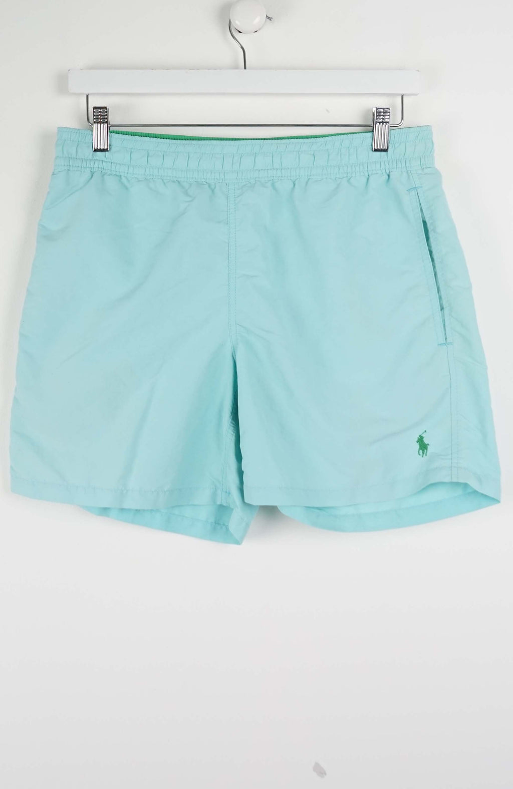 Light blue shorts with a brand logo on a white background