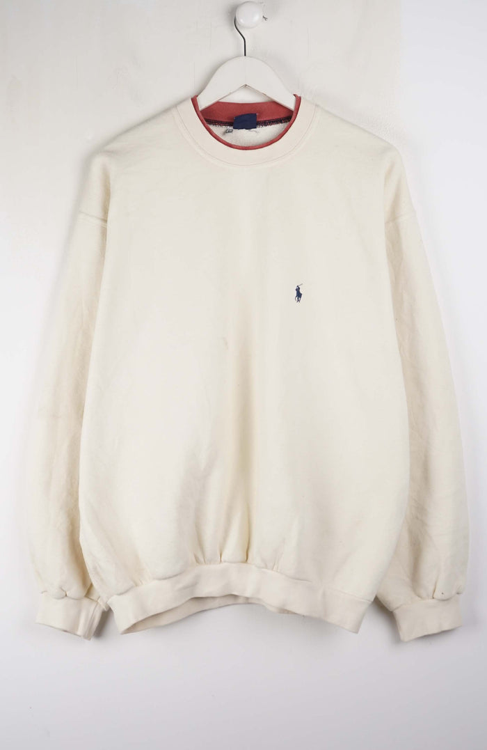 Beige sweatshirt with a small logo on a white background