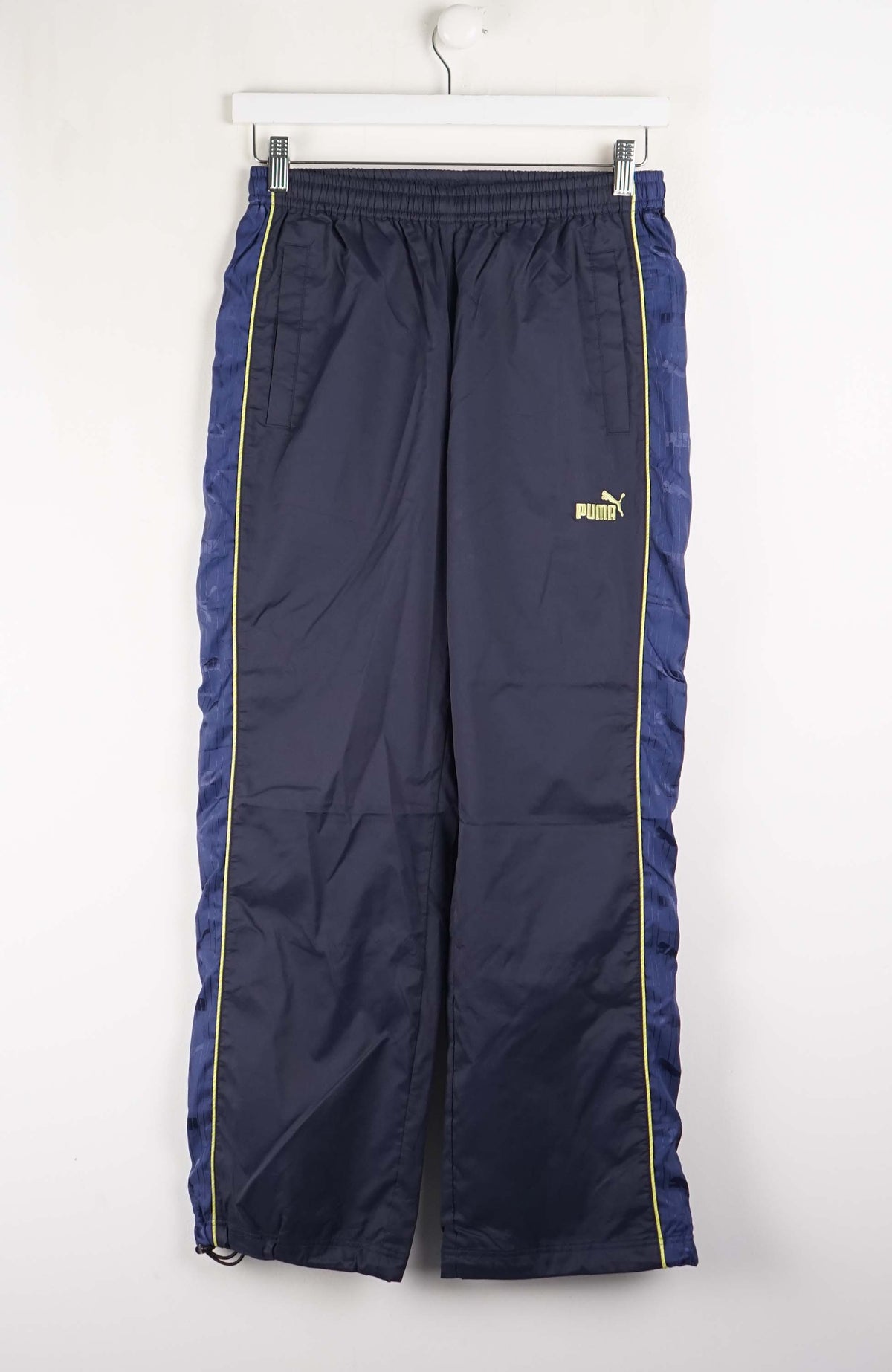 Navy blue pants with a yellow Puma logo on a white background