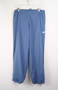 Blue pants hanging on a white hanger against a white background