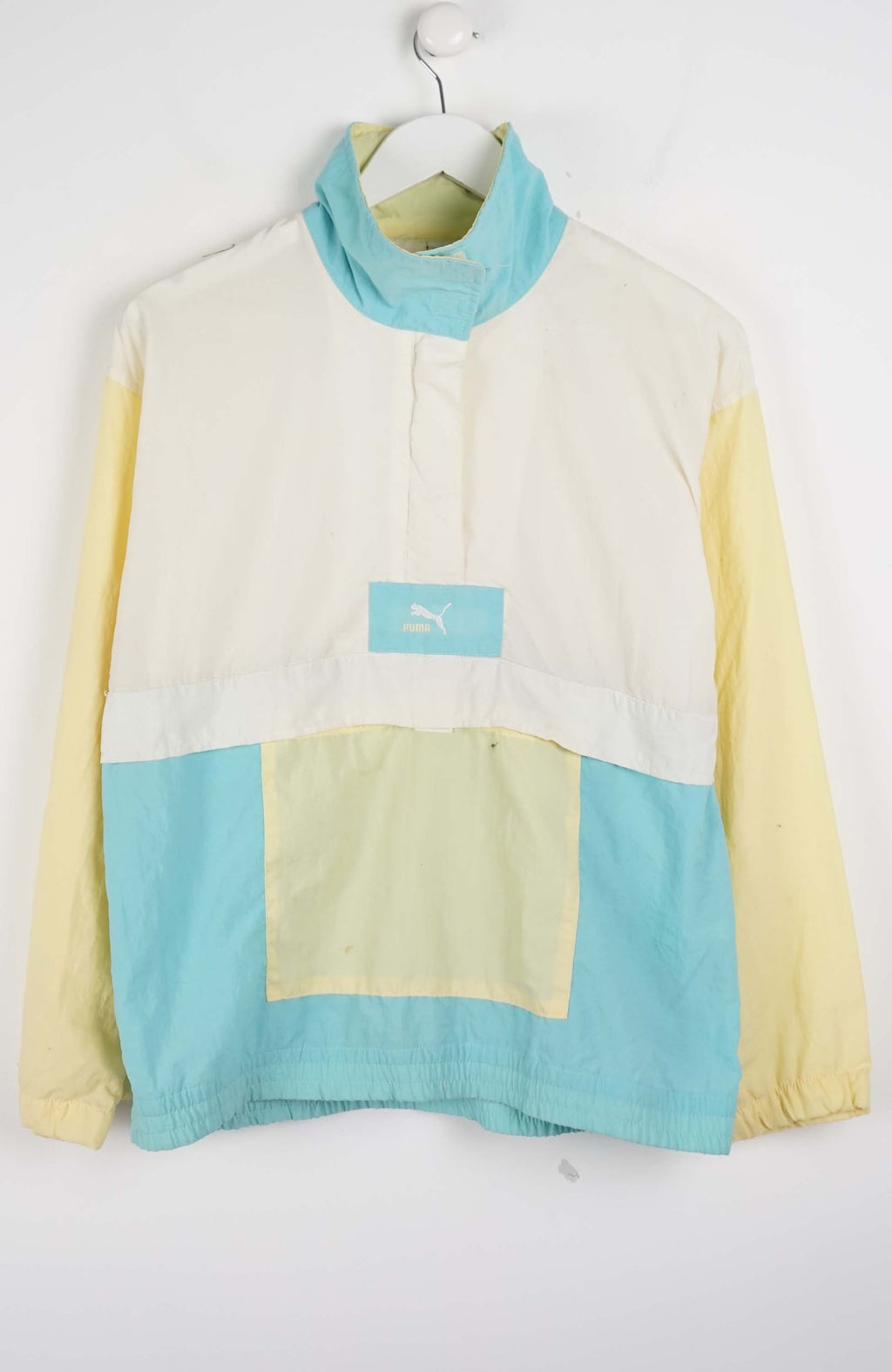 Color-blocked pullover with turquoise and yellow sections on a white background