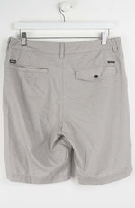Gray shorts hanging on a white hanger against a white background