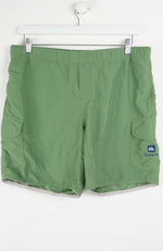 Green shorts with a brand logo on a white background