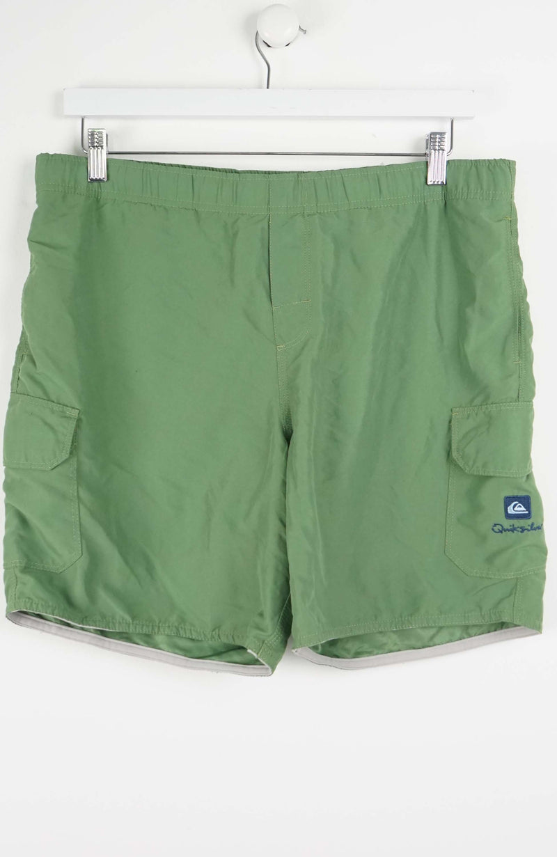 Green shorts with a brand logo on a white background