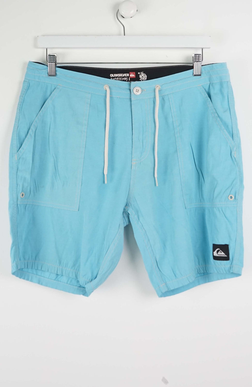 Light blue shorts with a brand logo on a white background