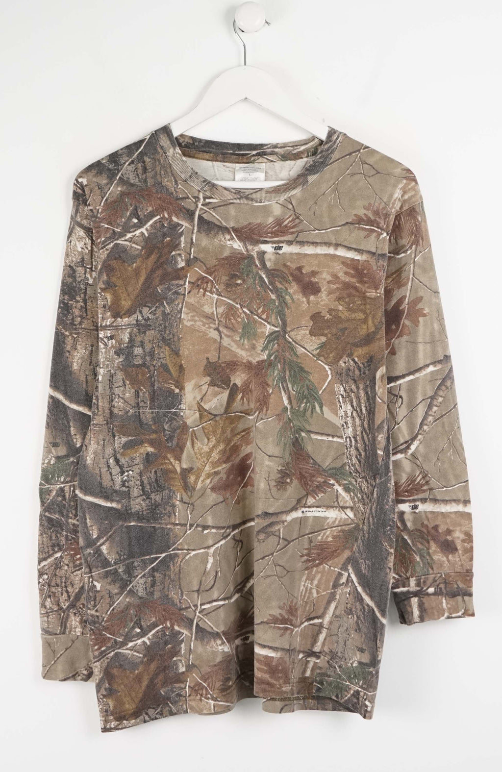 Camouflage-patterned long-sleeve shirt on a white hanger against a white background