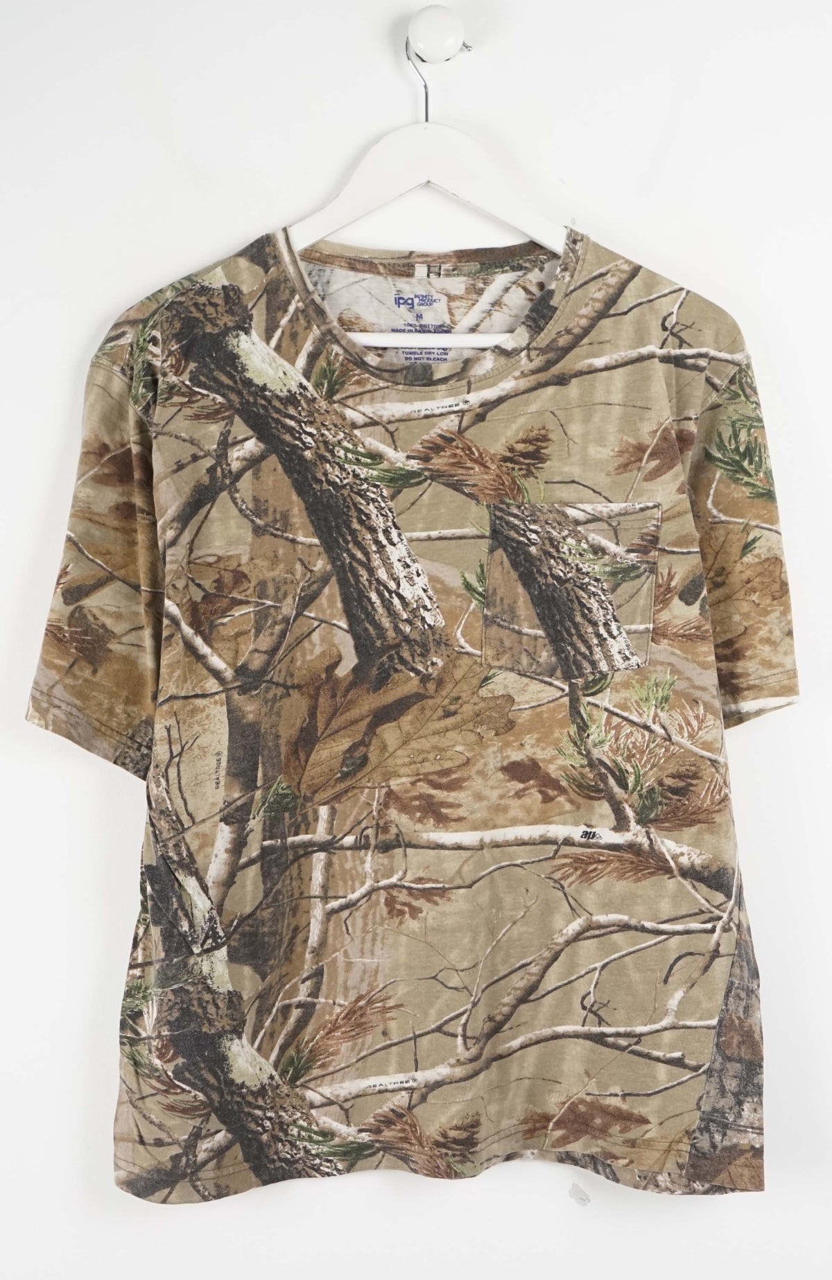 Camouflage-patterned shirt on a hanger against a white background