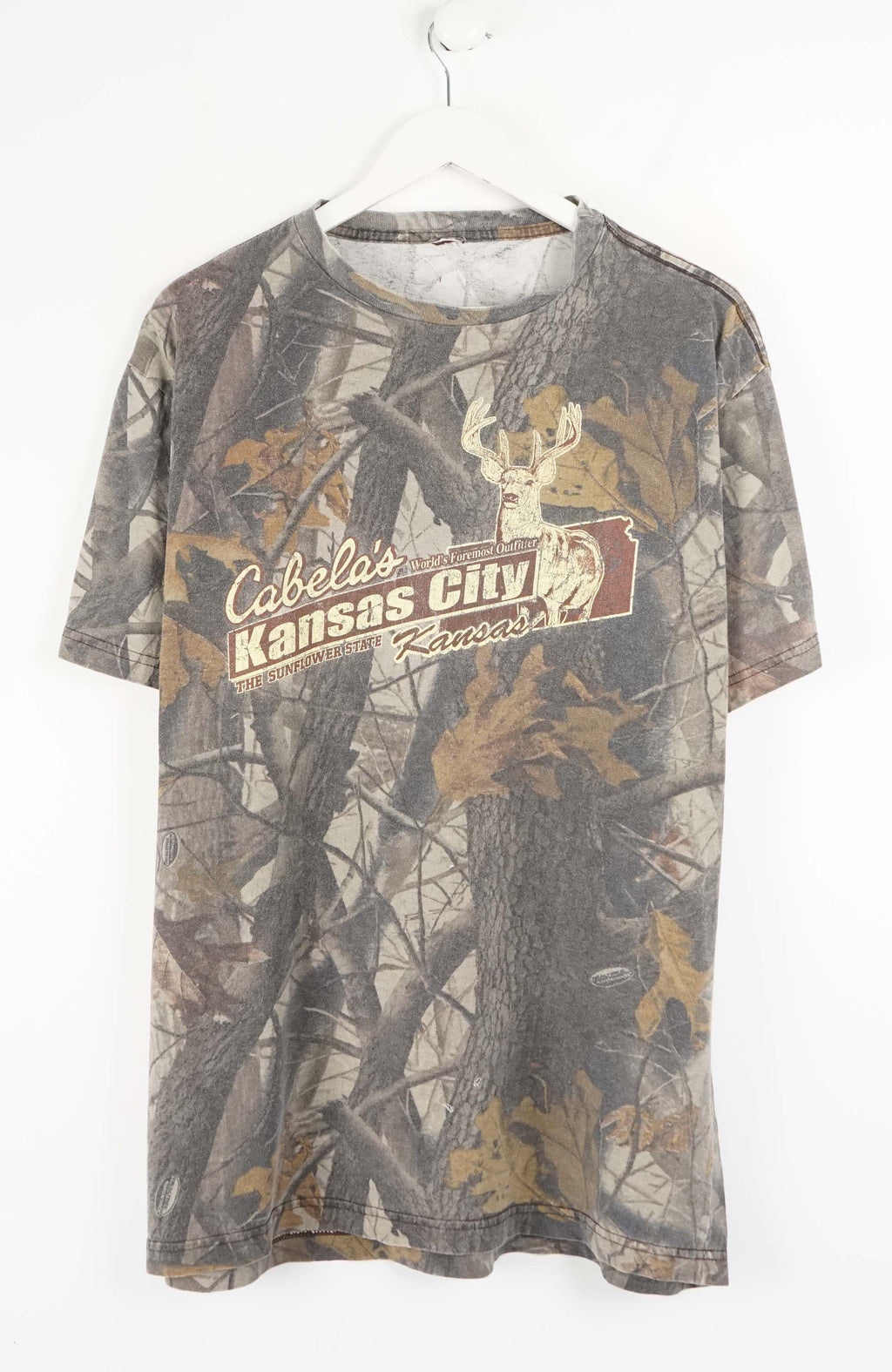 Camouflage-patterned t-shirt with Cabela's branding on a white background