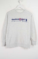 Gray Reebok sweatshirt on a hanger against a white background