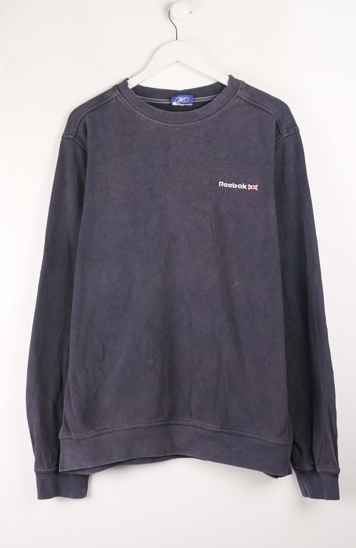 Dark gray sweatshirt with a small logo on a white background
