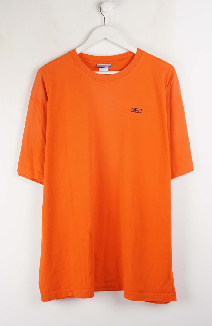 Orange t-shirt with a small logo on a white hanger against a white background