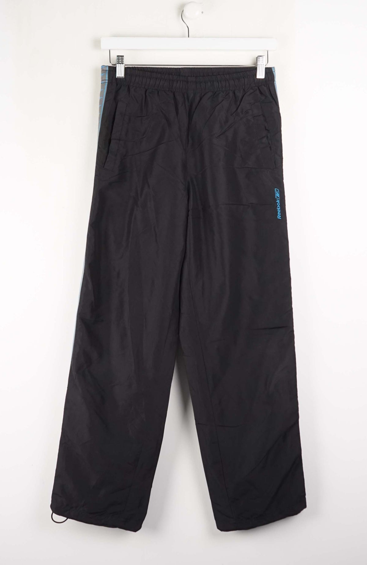 Black pants hanging on a white background