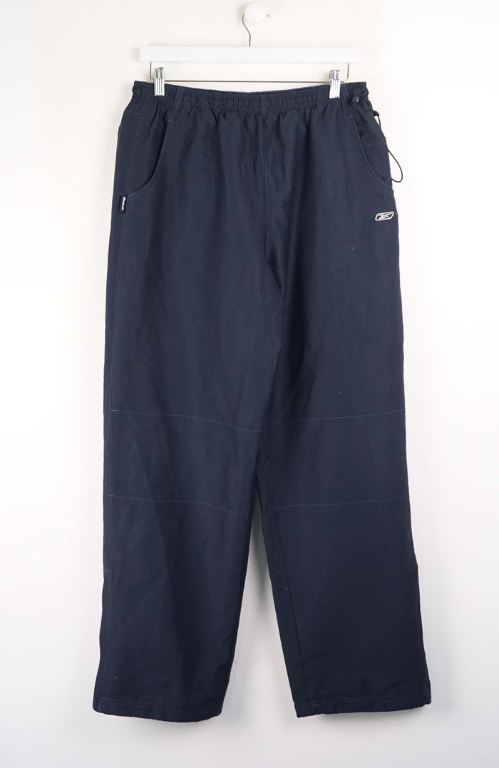 Navy blue pants hanging on a white background