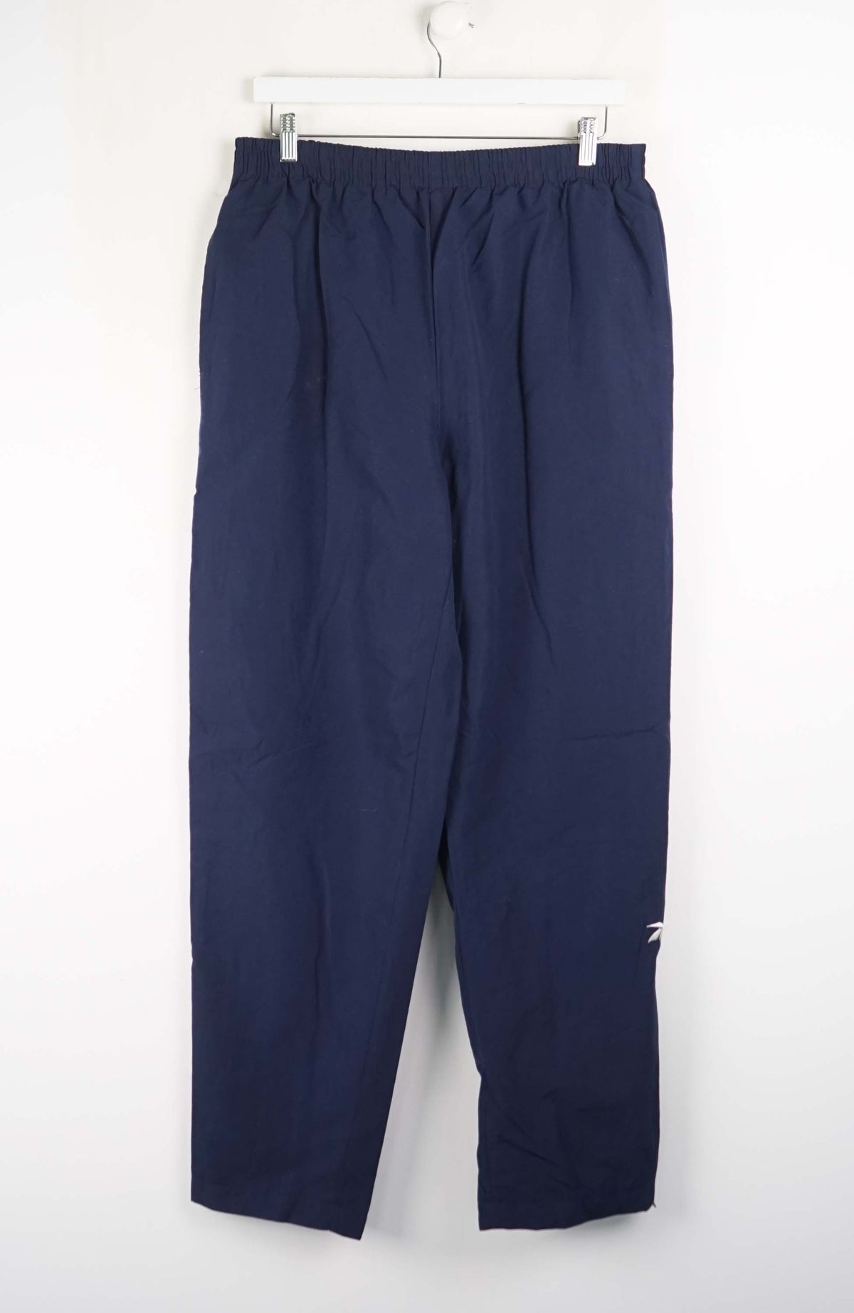Navy blue pants hanging on a white background