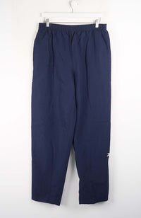 Navy blue pants hanging on a white background