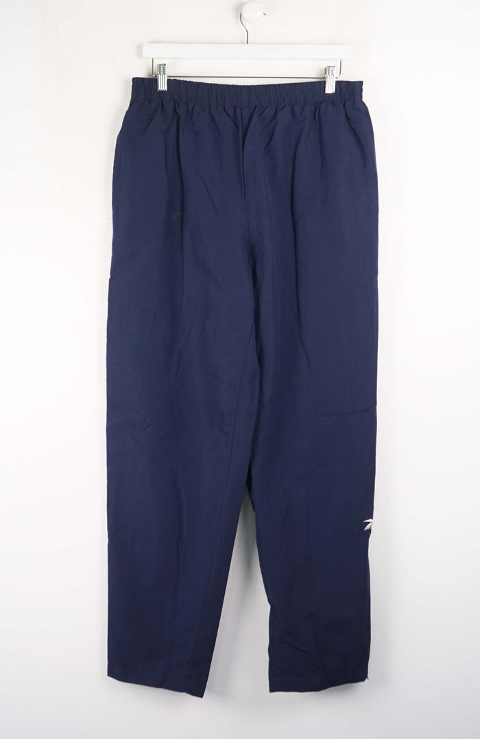 Navy blue pants hanging on a white background