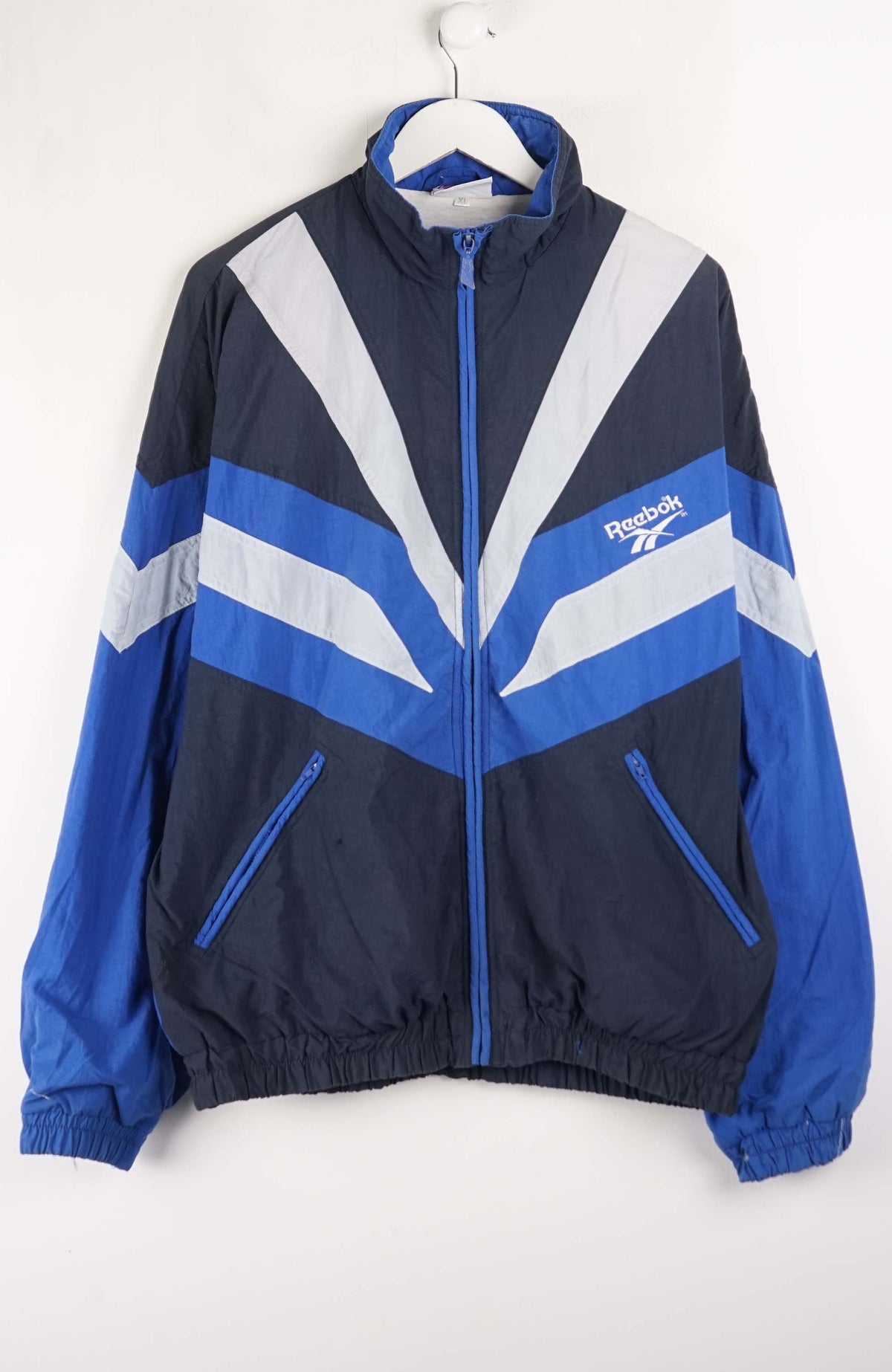 Blue and navy jacket with Reebok logo on a white background