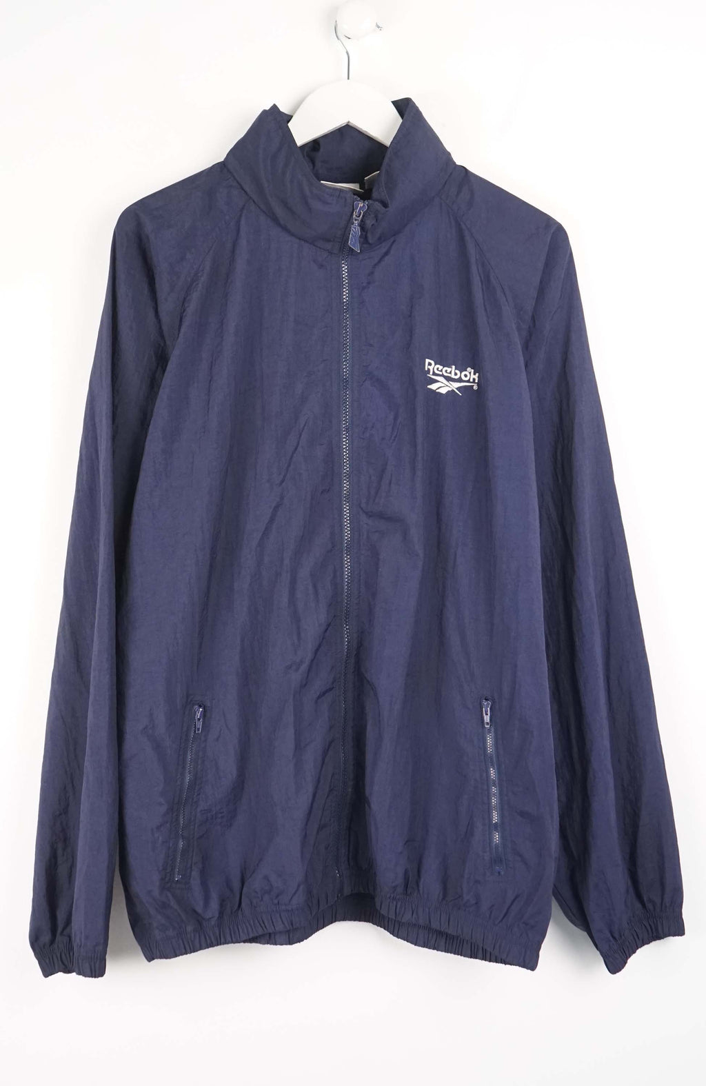 Navy blue jacket with Reebok logo on a white background
