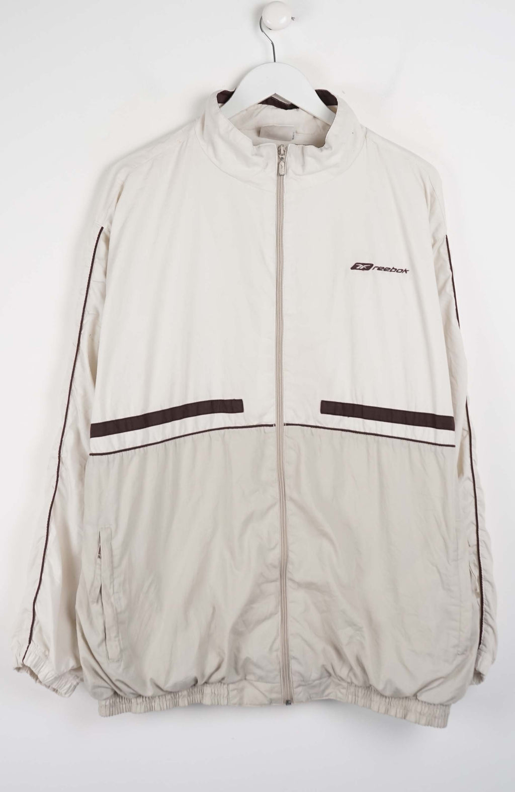 Beige jacket with black accents on a white hanger against a white background
